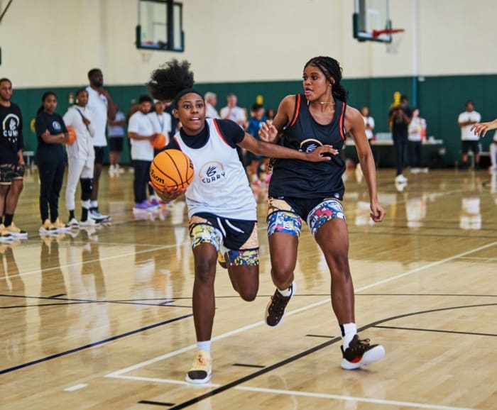 Two female basketball players compete at Stephen Curry's camp.